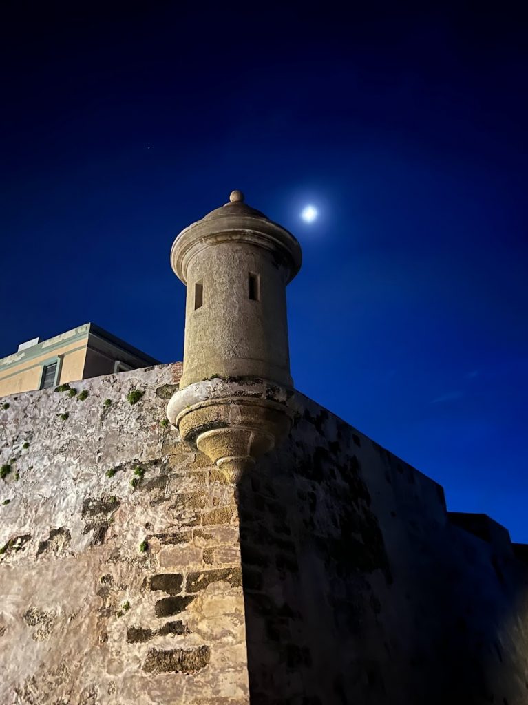 A photo of the moon above El Morro, the spanish fort in Old San Juan